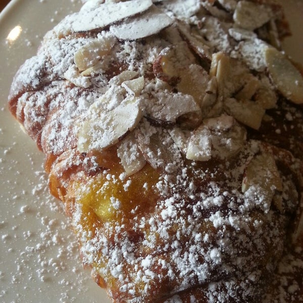 Stale almond croissant has runny yolk-like filling with large almond slices.