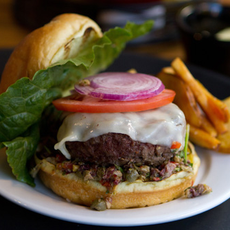 Chef Paul Sussman's Muffaletta burger was inspired by the muffaletta sandwich, which was created by Italian immigrants in New Orleans and consists of Italian cold cuts, cheeses and olive salad.