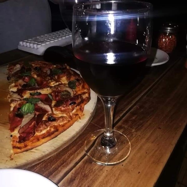 La pizza de jamos serrano y el vino tinto deliciosos