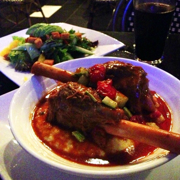 Braised Lamb Shank -- delicious and falling-off-the-bone tender and served with a creamy mascarpone polenta, sautéed zucchini, cherry tomatoes and a tasty rosemary au jus