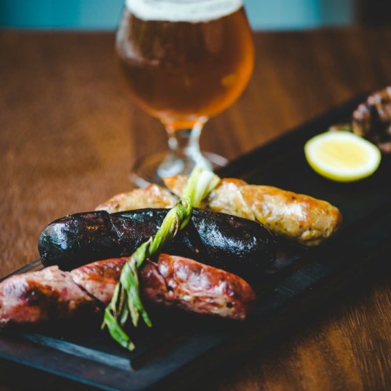 The mixto asado is a delicious, hearty selection of house-made sausages alongside smoky, charred scallions.