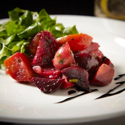 French and Mediterranean-influenced, this beet salad with mache, balsamic drizzle and white truffle vinaigrette is sure to add a little brightness to those cozy winter meals.