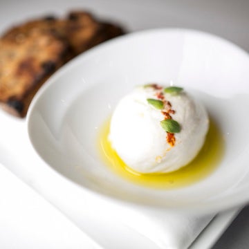 Diners can choose from Long Island sea salt-topped burrata on a small pool of fruity olive oil or a burrata flatbread accompanied by balsamic vinegar, wild arugula, garlic and chili flakes.