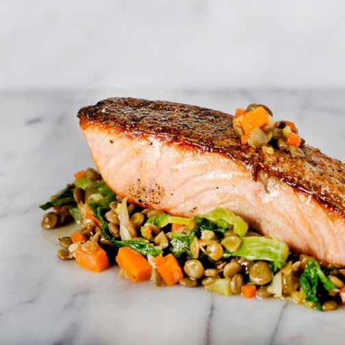 The Seared North Atlantic Salmon is atop a bed of delectable mixed vegetables.