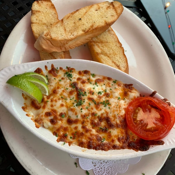 Broiled crab Parmesan - blue crab, butter, garlic, tomato, and Parmesan served with French bread and lime.  #evangelines #24hourfoodgeek Follow us at http://24hourfoodgeek.wordpress.com