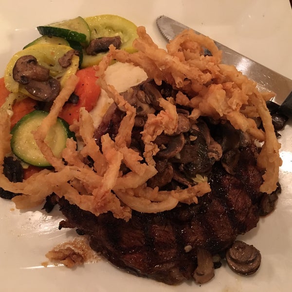 GRILLED TEXAS RUBBED RIB-EYE (THICK CUT 14OZ RIB EYE STEAK SERVED WITH GARLIC WHIPPED POTATOES, SEASONAL VEGETABLES AND TOPPED WITH HAND BATTERED ONION STRINGS, WITH EXTRA SAUTEÉD MUSHROOM)