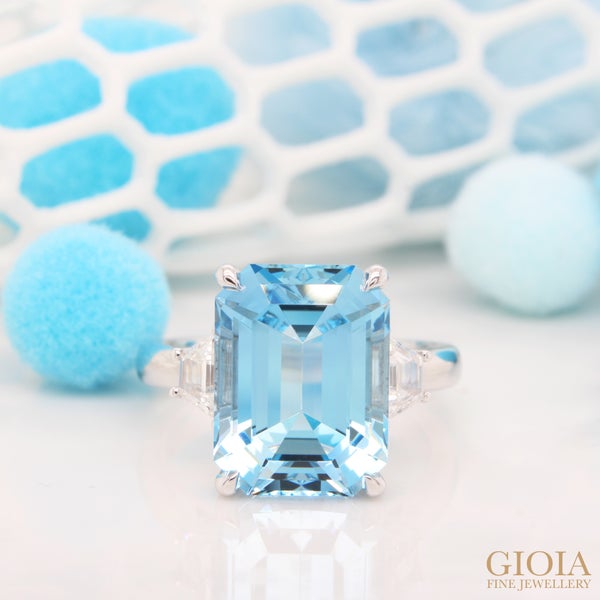 Aquamarine Ring End the month of march with this gorgeous aquamarine ring, absolutely stunning and timeless. Features a large 5.60ct vivid blue emerald-cut aquamarine accompanied by trapezoid diamonds