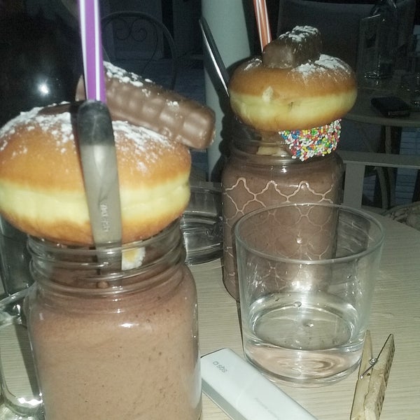 Chocolate.  It is being served with a donut filled with chocolate and a tiny chocolate  on top. The chocolate drink has a smooth texture, like a mouse. It's not watered of something. It costs 5€