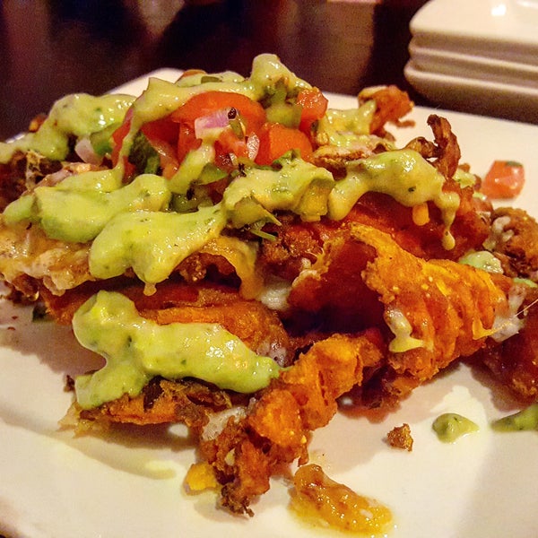 The Sweet Potato Nachos have a unique and delicious twist. They're made with sweet potato waffle fries, pico de gallo, jalapeños, avocado sauce, & cheese!