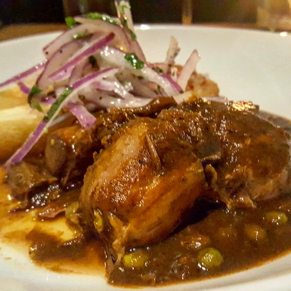 The Seco de Cordero is an incredibly tender braised lamb leg marinated in seco sauce (cilantro, chicha de jora, dark beer), fried yucca, & salsa criolla,  served with tacu tacu.