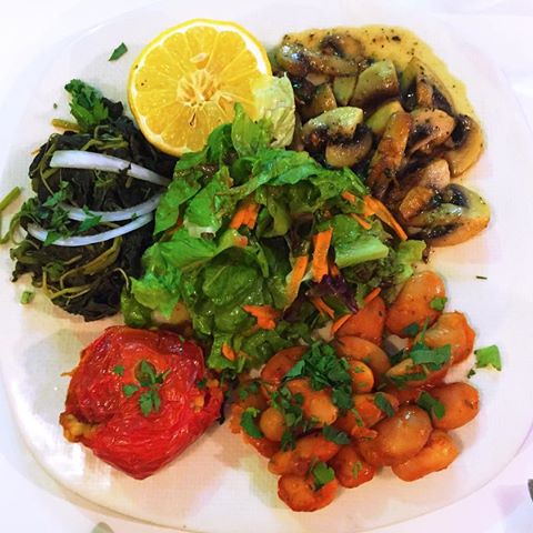 Vegetarian heaven! Dandelion greens, tomato stuffed with couscous, gigandes (butter beans) and mushrooms Salad !