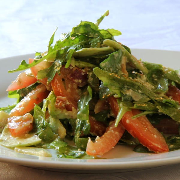 Знаменитый американский салат из рукколы, спелого авокадо, помидоров и жареной куриной грудки, замаринованной с орегано и элегантной заправкой.