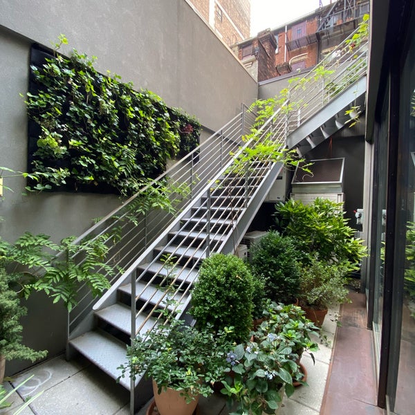 Find a flight of stairs on the ground level leading to a small garden. The garden would have been an oasis if not for all the exhaust fans blowing down on it from surrounding buildings