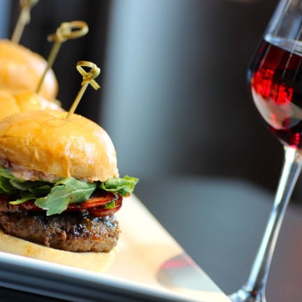 Drakes Haus is adding their own red liquid (Merlot!) to burgers before grilling them, resulting in ultra-juicy meat topped with inventive international fixins.