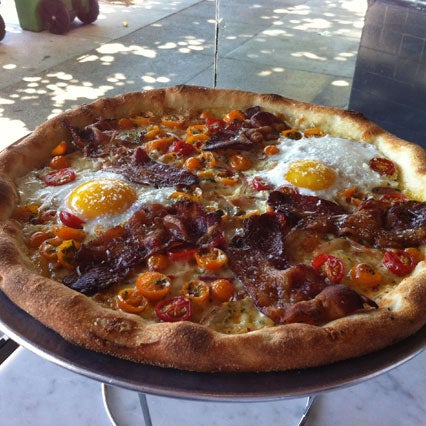 Their breakfast pizza is amazing: a mozzarella and provolone pie with Sweet Mariquita tomatoes, sliced red onion, hot chili flakes, 5 crinkled strips of Neuske bacon, and two golden fried eggs.