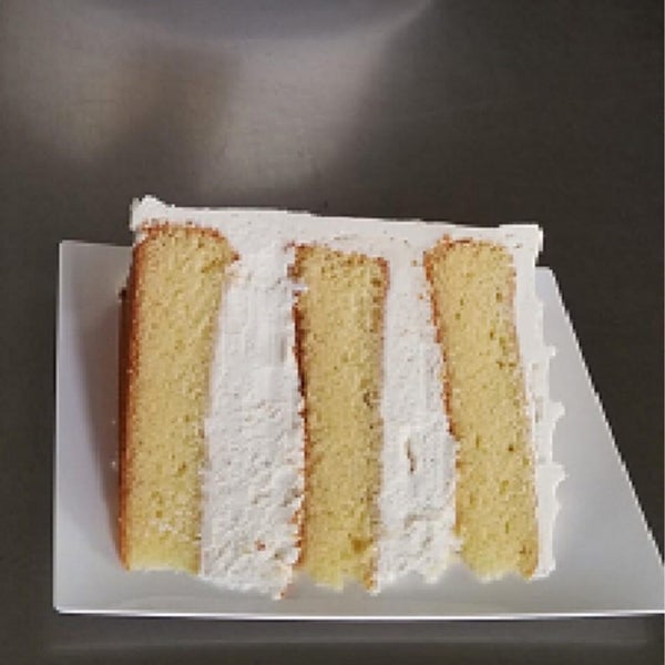 Our rum infused yellow cake dressed  in vanilla bean frosting is packaged for single sliced and whole cake purchases. Visit our locations or take a look at thecakepusher.com for to see our flavors!