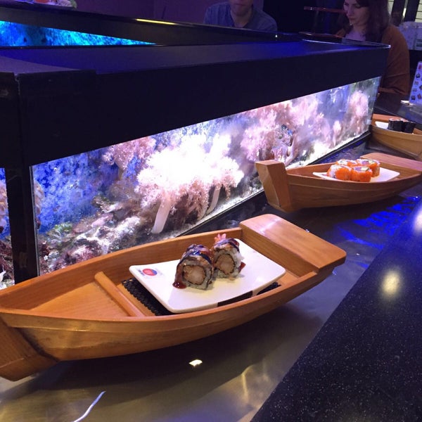 Very cool sushi bar. Love the rolls going by on those little boats!