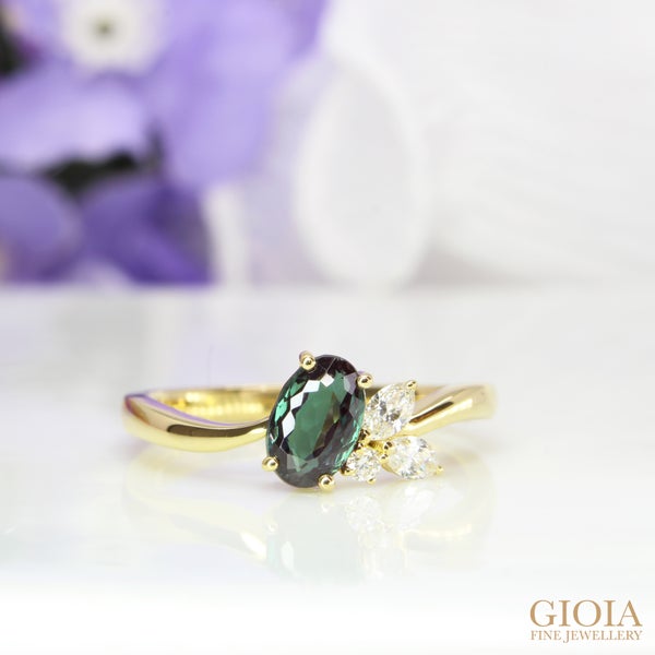 Alexandrite Cluster Diamond Ring Featuring an Alexandrite displaying a myriad of colours under ambient and natural daylight lighting.