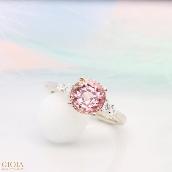 Tourmaline Engagement Ring Stunning round brilliance tourmaline with excellent sparkle and shine, accompanied by side tapered round diamonds. Sweet pink colour of tourmaline