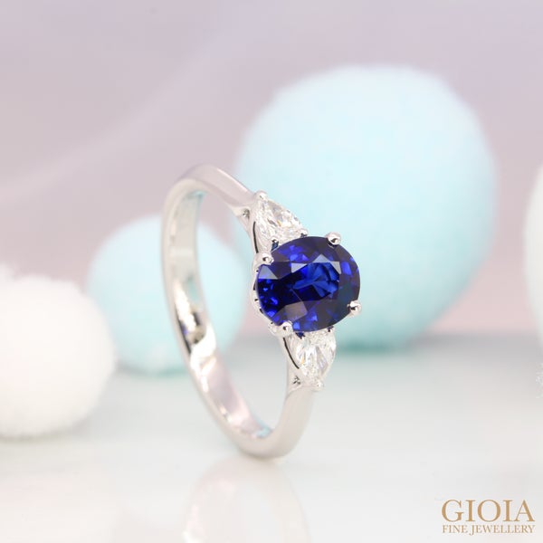 Trilogy sapphire proposal ring with pear-cut diamonds Features a center vivid blue sapphire with side pear diamond ring, an elegant combination of brilliance and shapes.
