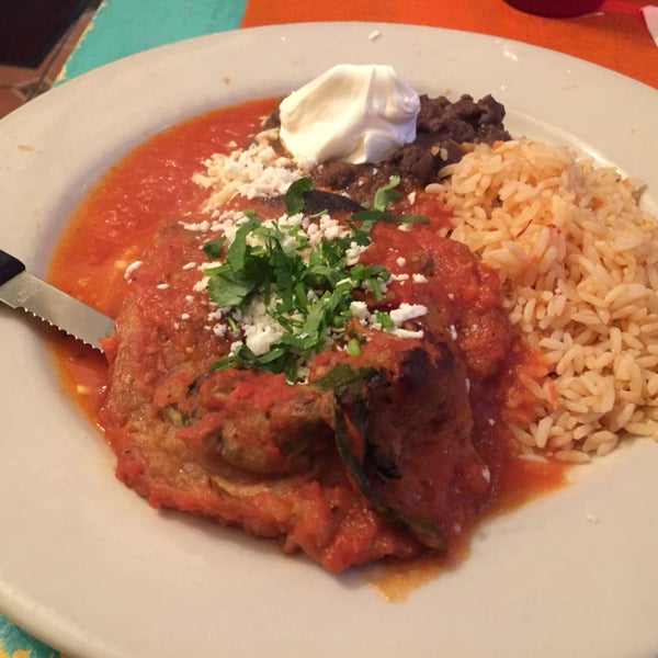 piccadillo poblano relleno (pepper stuffed with ground beef) with refried beans, sour cream, and rice