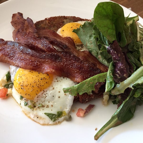 potato pancake and fried eggs breakfast served with green salad, and added bacon