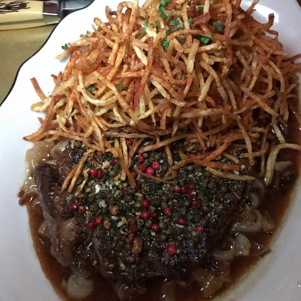 Sit at the bar and order the peppercorn crusted steak, drinks, and seasonal vegetable dishes.
