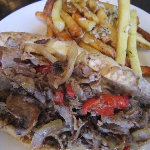 "Italian Dip", shaved ribeye, peppers, onions, mushrooms & Fontina cheese, dipped in Au Jus and served with rosemary/parmesan fries