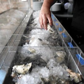 The menu lists eight to 12 oysters daily, evenly split between the East and West coasts; a side card offers accurate tasting tips.
