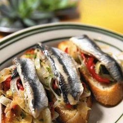 With a plate of boquerones (cured white anchovies on grilled bread) and a glass of txakolina in hand, you might think you feel sand between your toes.
