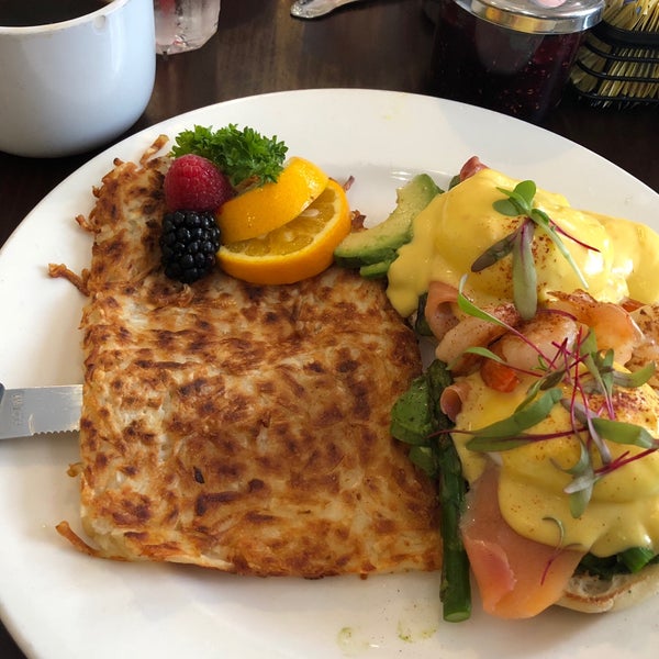 Egg Benedict with smoked salmon and shrimp is delicious, served with hash browns.