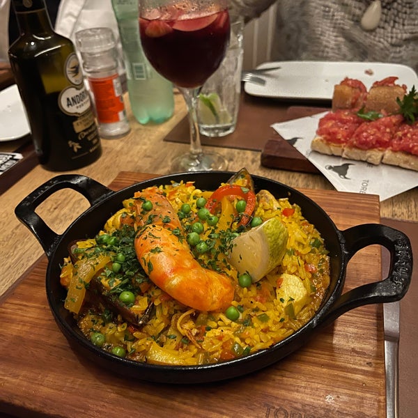 Tapas e pratos da cozinha espanhola com destaque para a deliciosa paella servida em porções individuais em um prato de ferro. A sangria também é muito bem preparada e vale à pena experimentar.