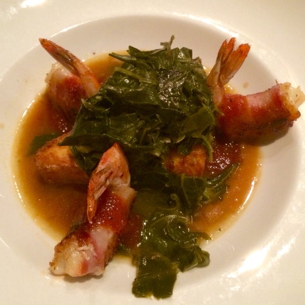 The bacon wrapped shrimp over a Delta grind grit cake and turnip greens ..