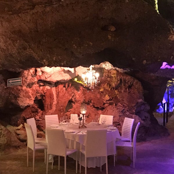 Diner at a cave from thousands of years with estalactites and estalagmites all around.