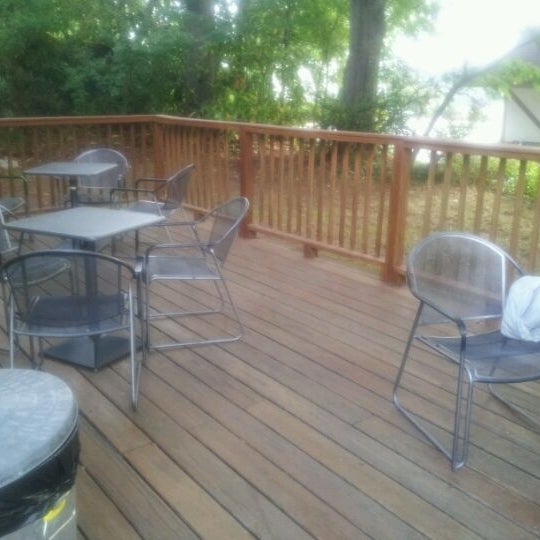 Shaded outdoor deck with three tables, each with 3 chairs