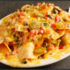 Try the XXL garbage nachos done up with chili, canned jalapeños, and that ooh-so-nasty, ohh-so-good, ooey, gooey, oozy nacho cheese!
