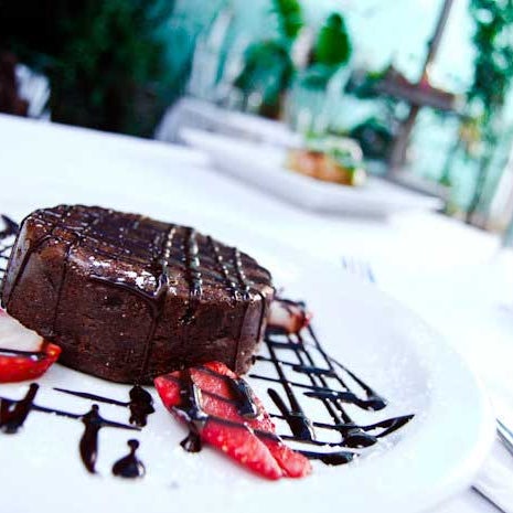 Indulge in the rich decadence of Triptych's Warm Chocolate Melted Cake. Powdered with fine sugar and topped with fresh strawberry slices, the cake is just waiting for you to fall into its ooze.