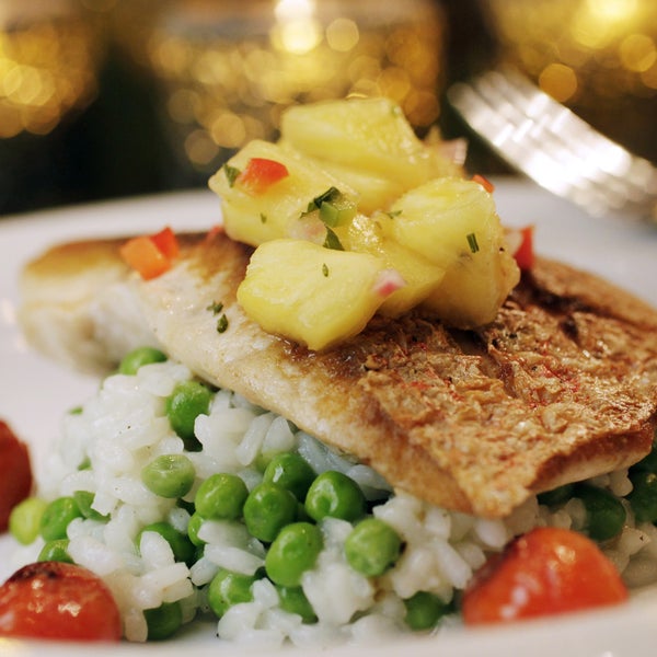 Savor the Grilled Snapper with sweet pea risotto, roasted cherry tomatoes and grilled pineapple salsa.
