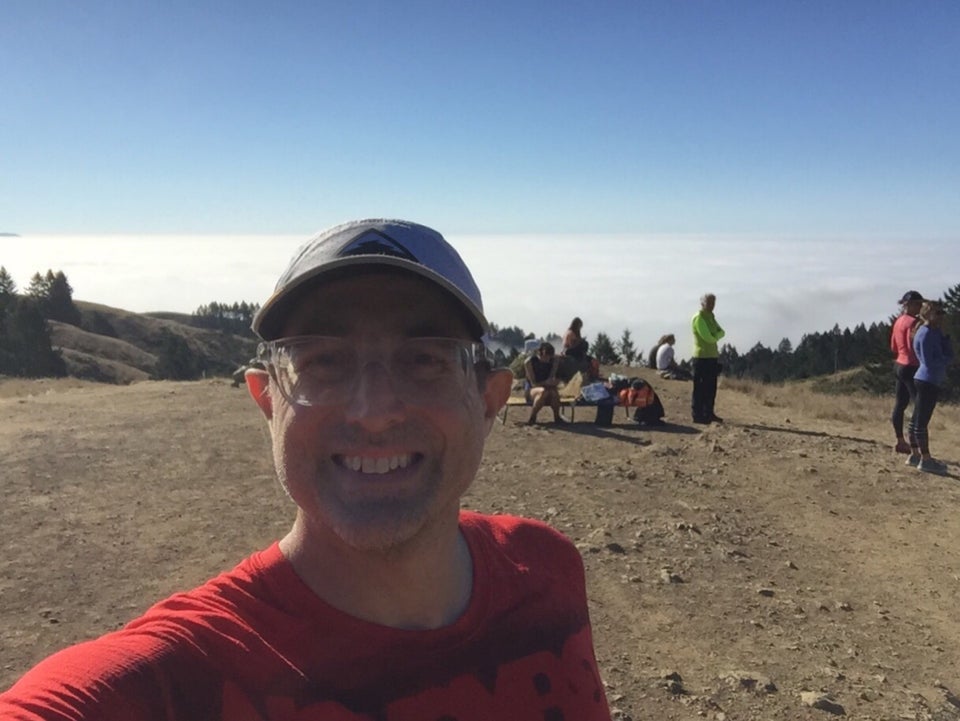 Tantek on top of Cardiac Hill, above the clouds, a few spectators standing behind him.