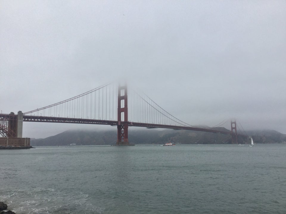 Golden Gate Bridge viewed from Fort Point, solid white fog enveloping the tops of its towers.