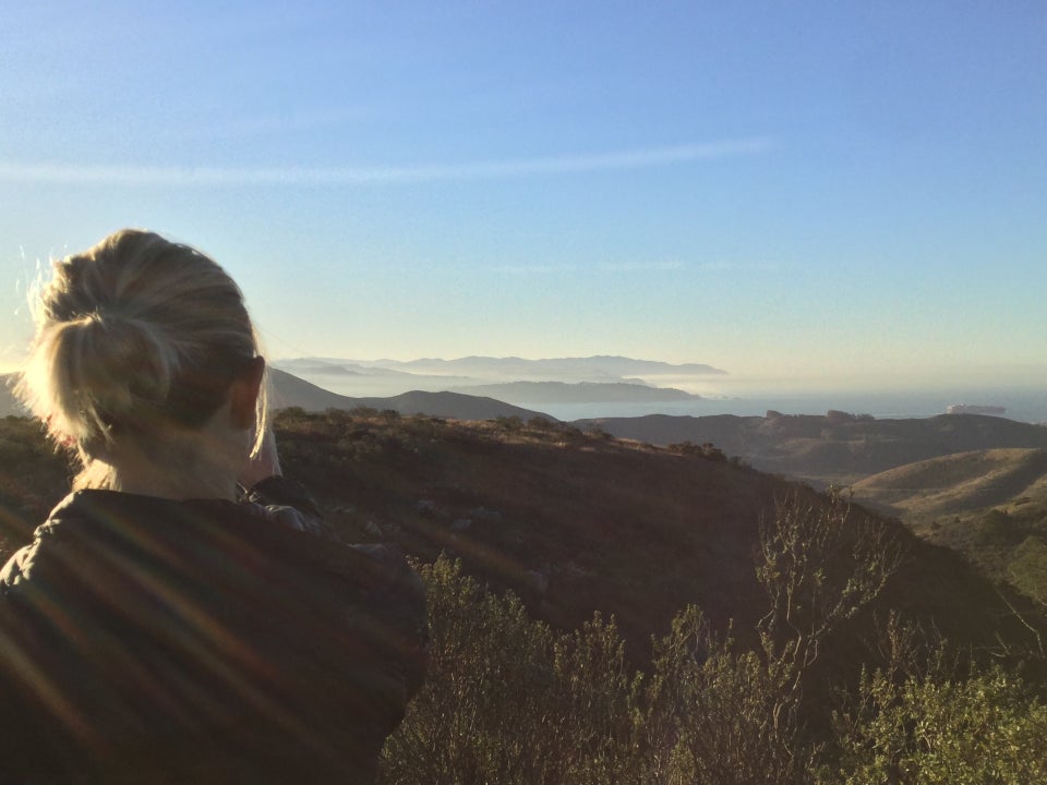 Emily taking a photo, distant hills, haze, the Pacific Ocean, and Marin Headlands.