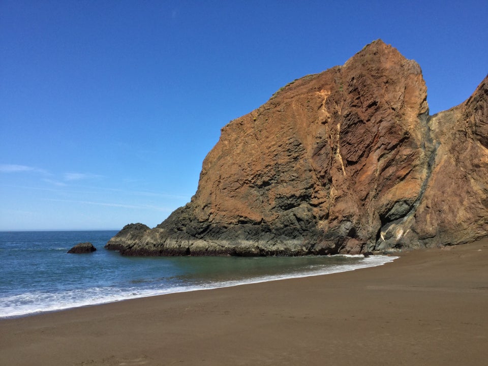 Tennessee Beach looking north to the red brown rocky hill