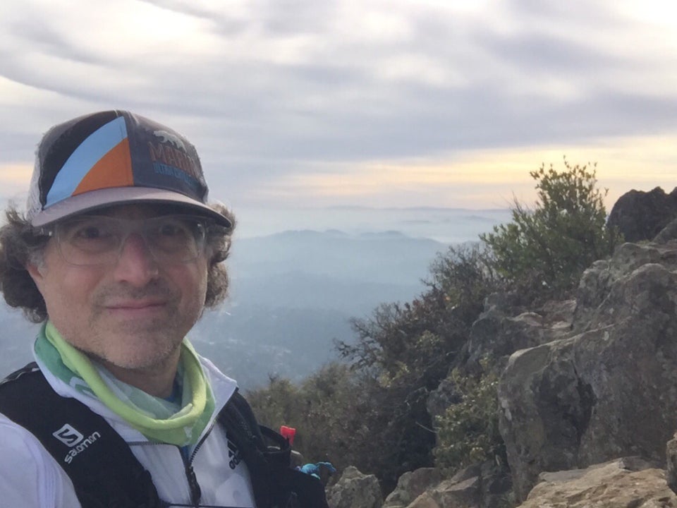 Tantek taking a selfie at Mount Tam East Peak with a hazy view of San Francisco in the distant background.