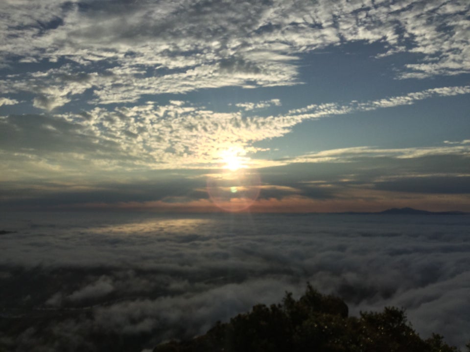 Sun rising above a few layers of clouds viewed from the Mount Tam East Peak